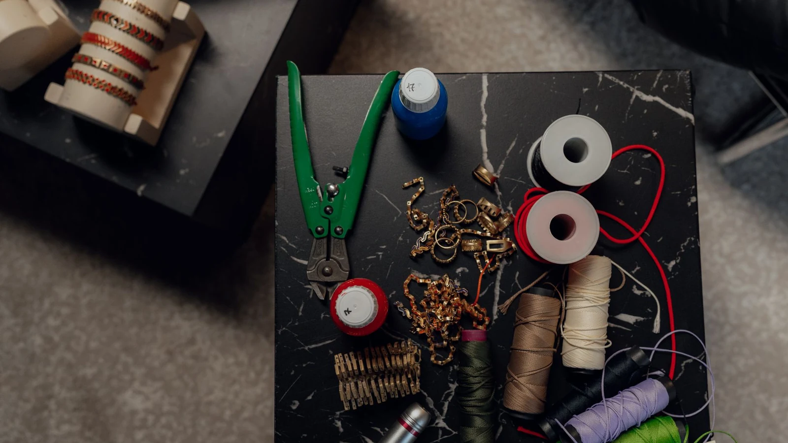 Top view of a crafting table with tools, spools, and jewelry making materials. — selected for United Kingdom readers