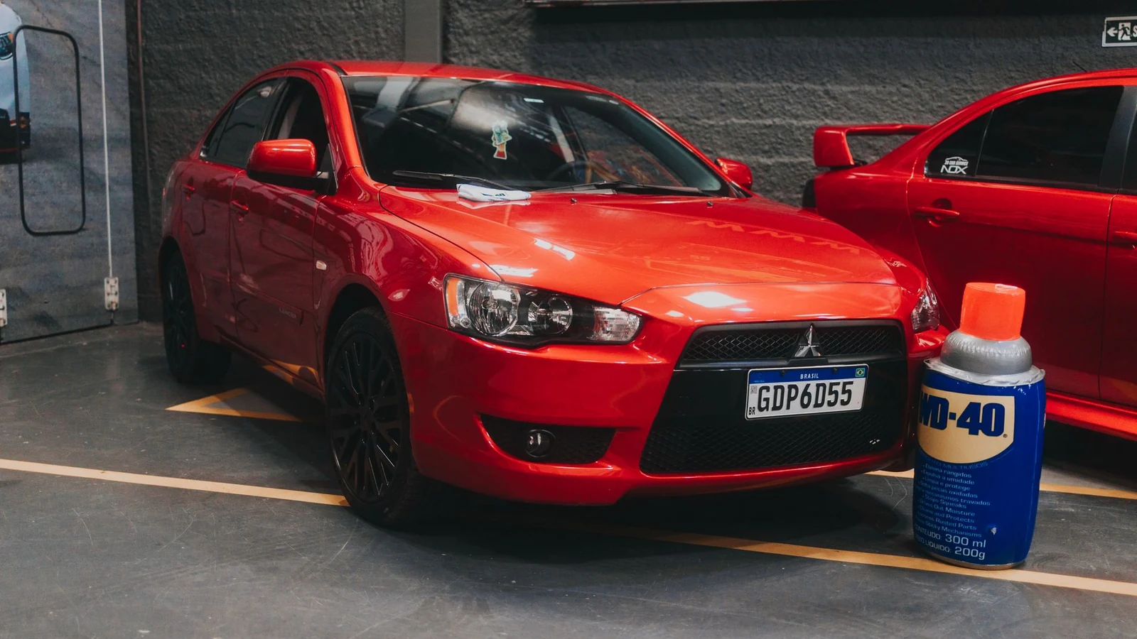 Bright red car parked indoors near a WD-40 can, showcasing a shiny modern vehicle in a garage. — selected for United Kingdom readers