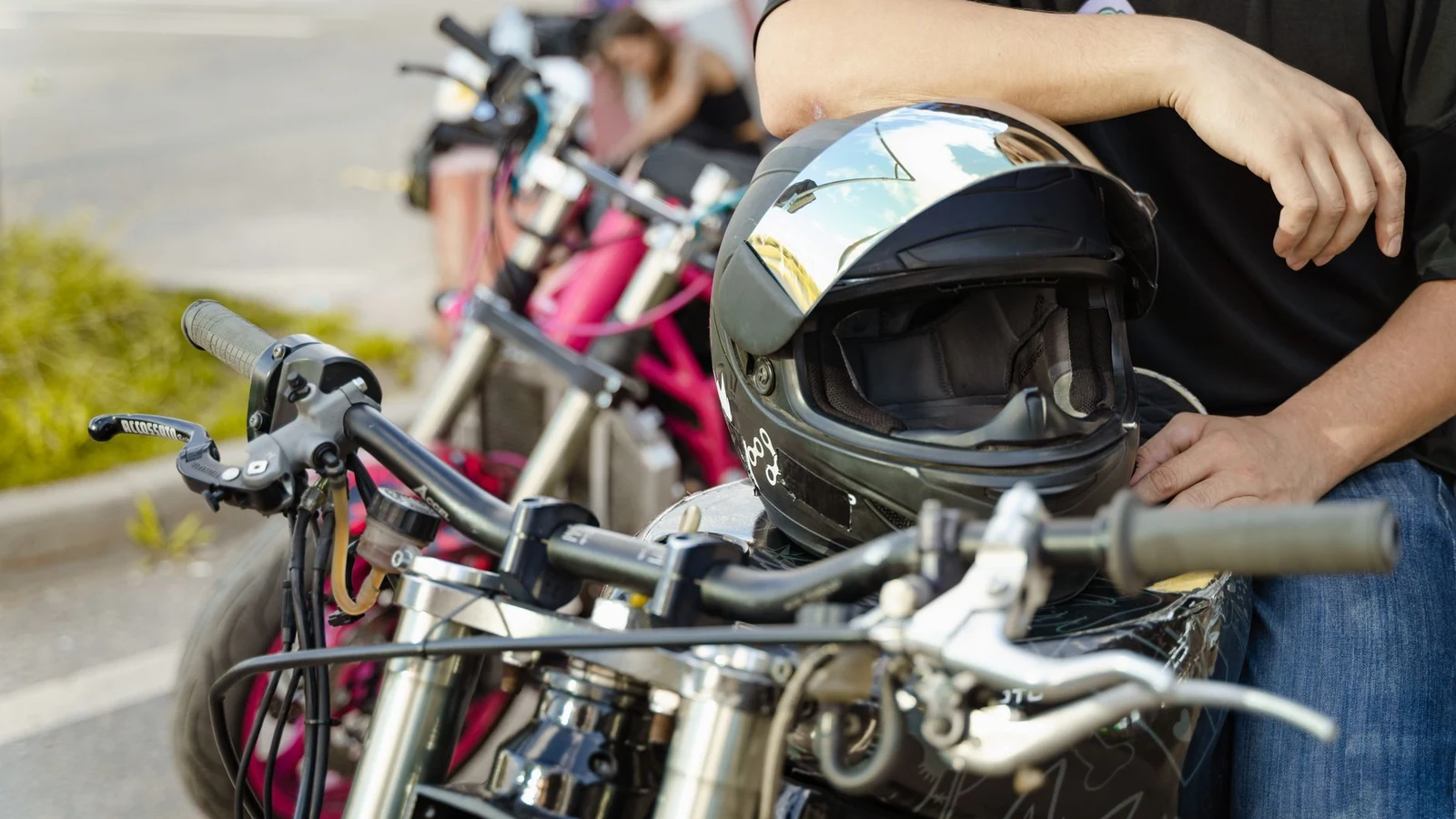 Motorcycle parked with helmet on handlebar and rider nearby, ready for adventure. — selected for United States readers