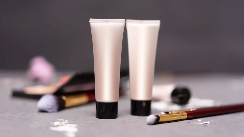 Close-up of skincare tubes with makeup brushes on a table, symbolizing beauty and self-care. — selected for United Kingdom readers