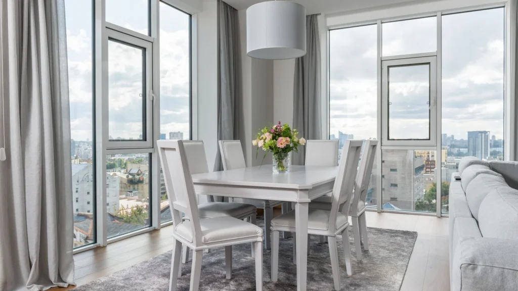 Interior of spacious contemporary dining room with stylish light furniture and panoramic windows in daylight — selected for United Kingdom readers