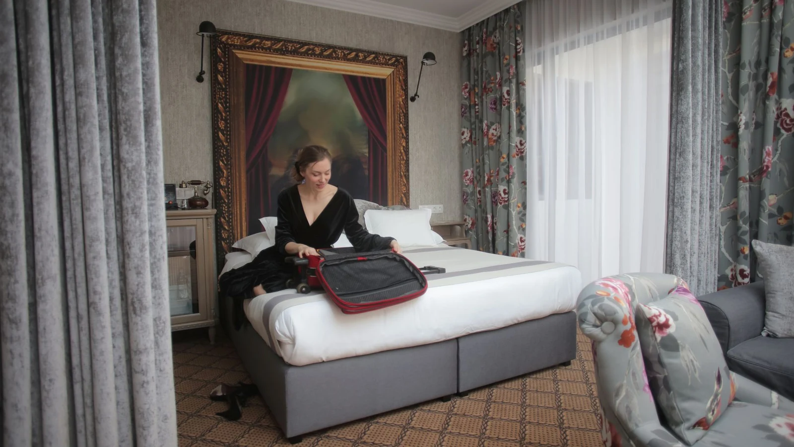 A woman in a chic hotel room packing her suitcase, ready for travel. — selected for United States readers