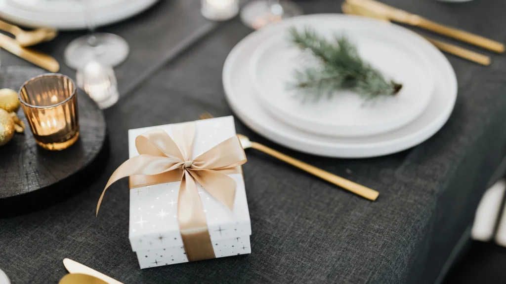A festive table setting featuring a wrapped gift box with a ribbon, perfect for winter celebrations. — selected for United Kingdom readers