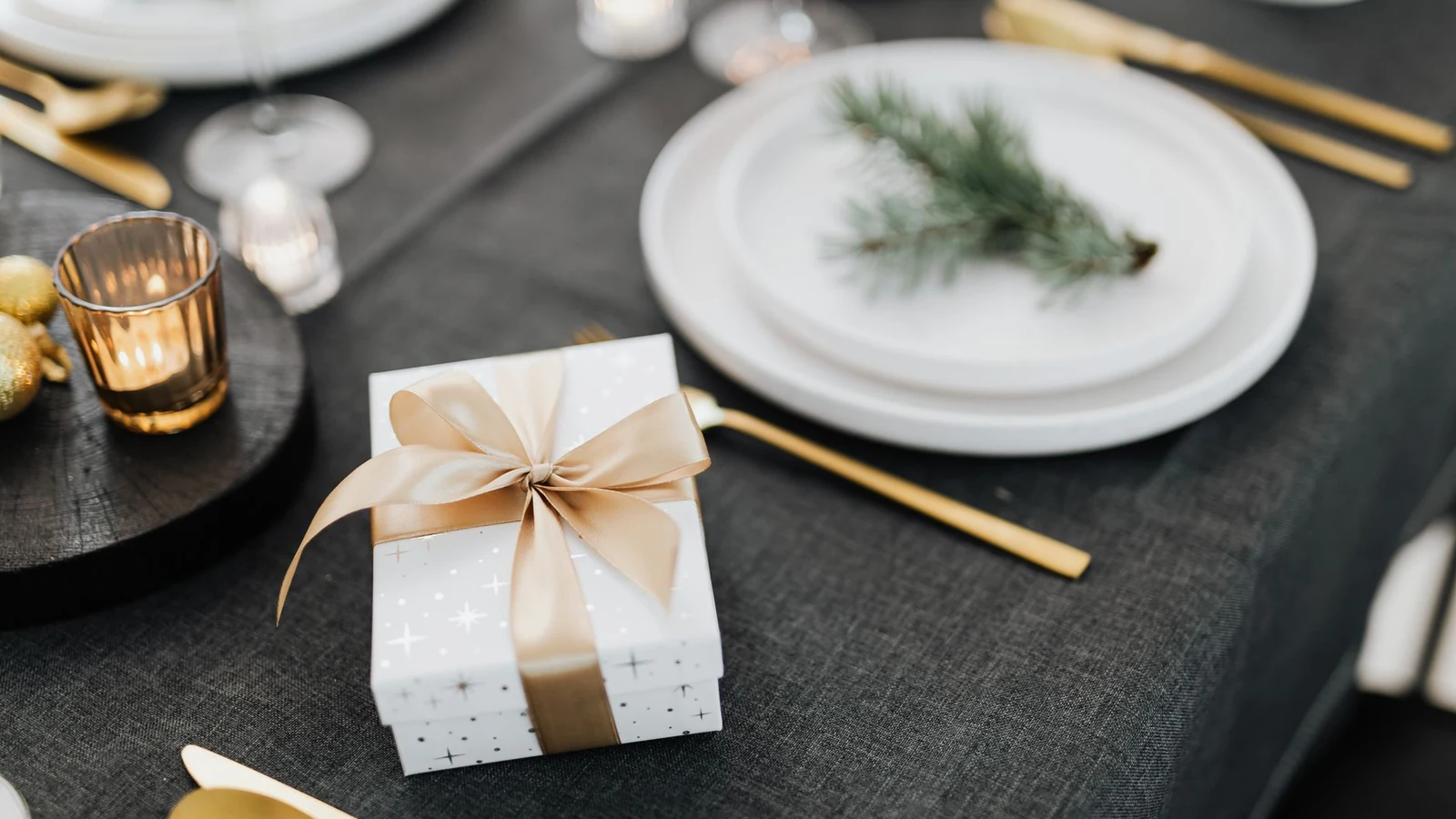 A festive table setting featuring a wrapped gift box with a ribbon, perfect for winter celebrations. — selected for United Kingdom readers