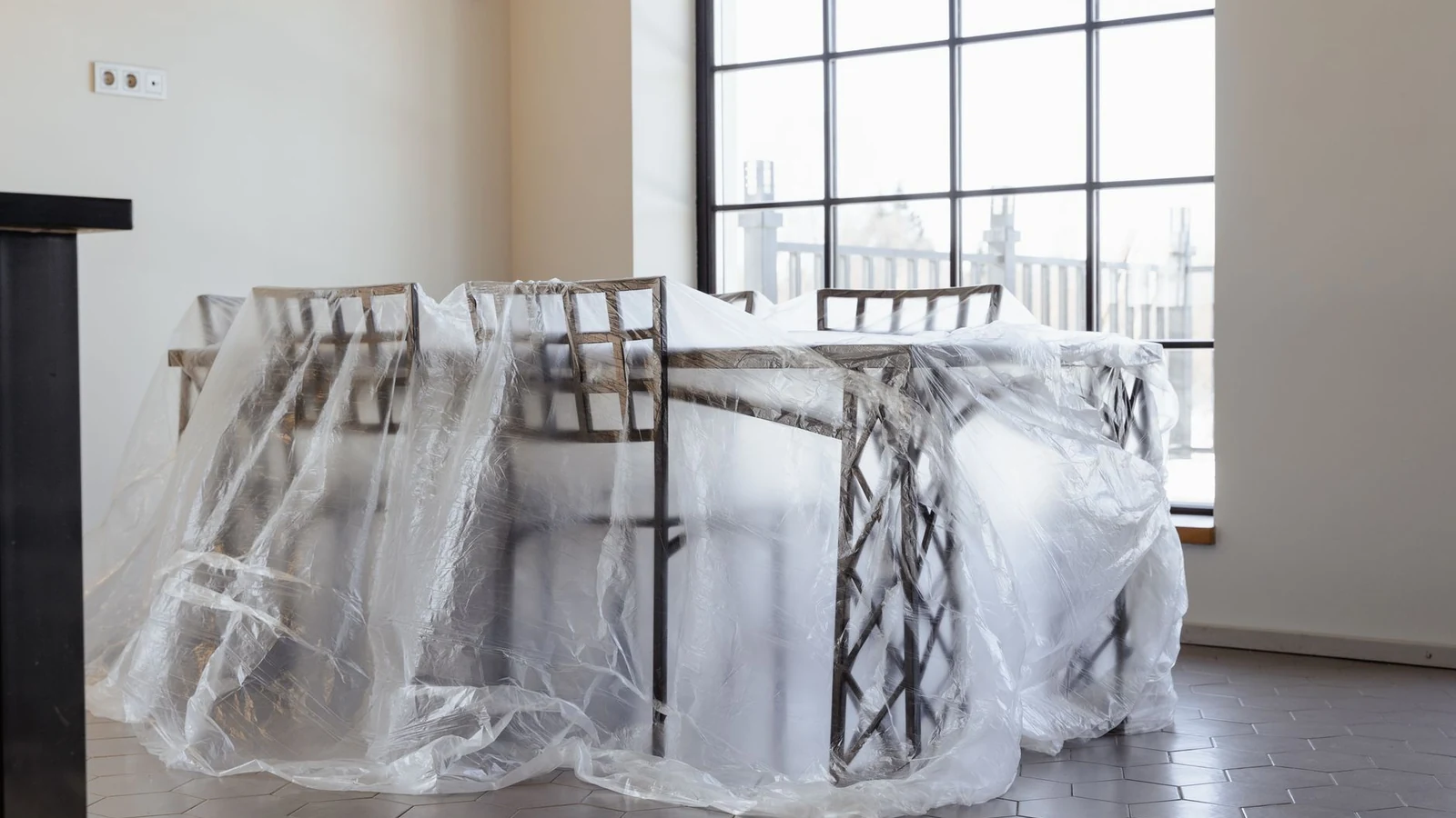 Dining chairs and table covered in plastic, a new home interior ready for moving in. — selected for United Kingdom readers