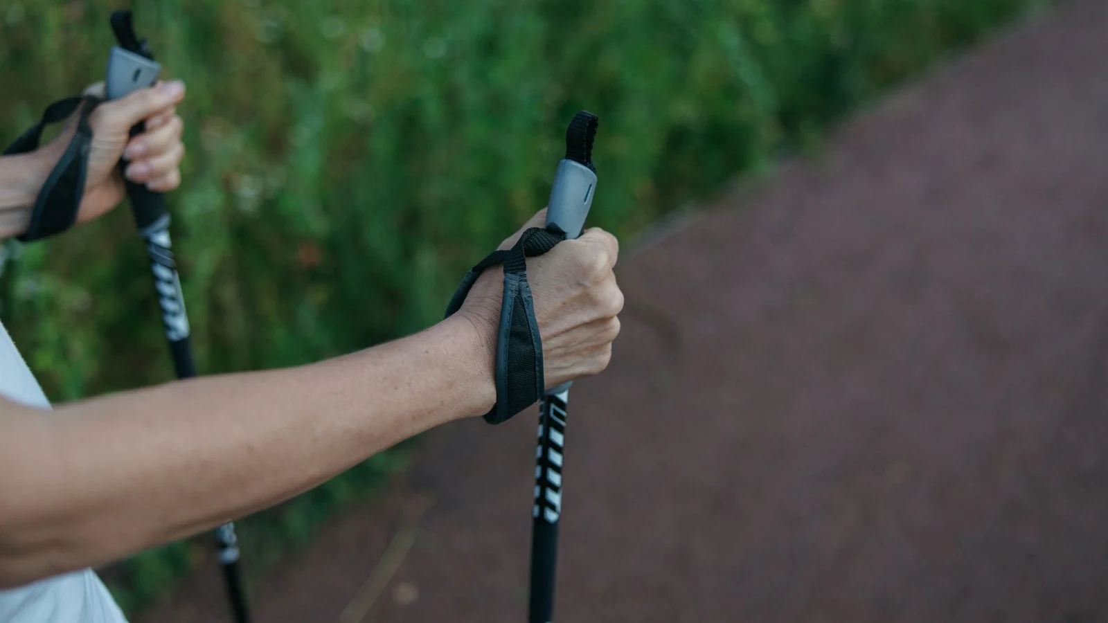 Close-up image of hands gripping walking poles on a trail, showcasing outdoor fitness activity. — selected for United Kingdom readers
