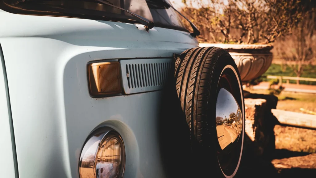 Close-up of a classic Volkswagen van with a spare tire, outdoors in warm, sunny light. — selected for United Kingdom readers