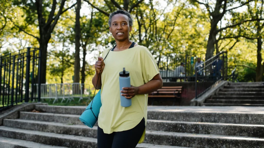 Active woman takes a break during her outdoor workout in a sunny park. — selected for United Kingdom readers