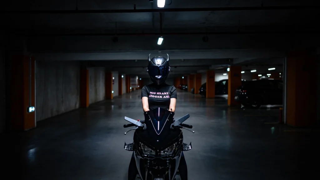 Motorcyclist wearing helmet on a motorcycle in a dimly lit parking garage, creating a cinematic feel. — selected for United States readers