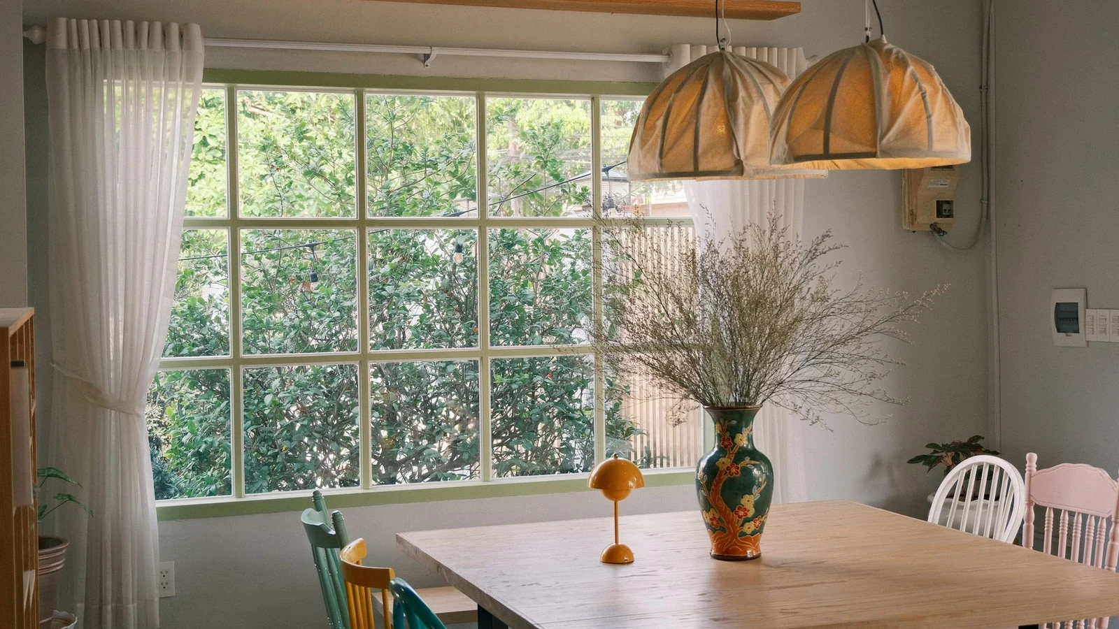 Bright dining room featuring a rustic table, colorful chairs, and natural light. — selected for United Kingdom readers