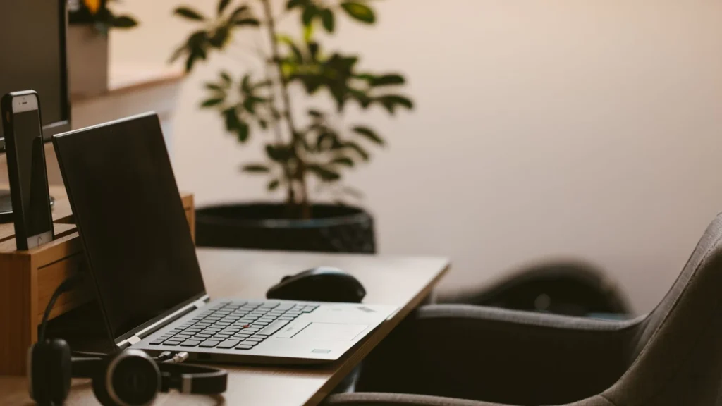 A cozy home office workspace with a laptop, headphones, and a plant. Ideal for remote work. — selected for United States readers