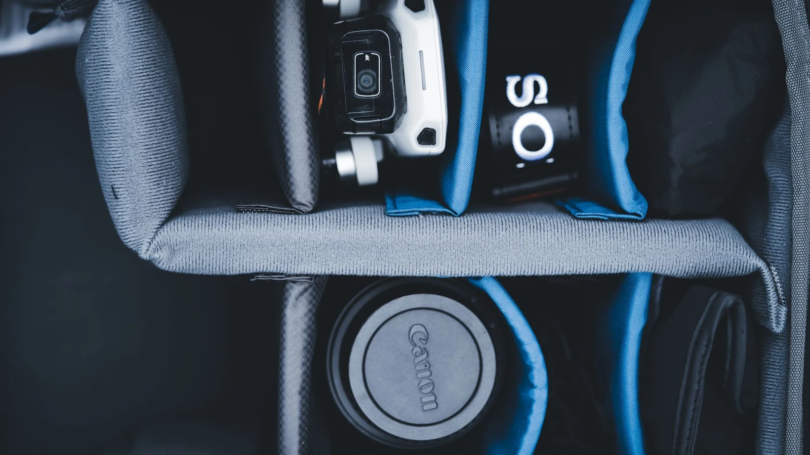 Flat lay of a camera backpack with organized gear, compartments, and gadgets for travel. — selected for United States readers
