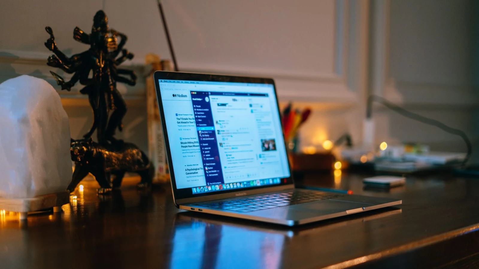 A cozy home office setup with a laptop on a wooden desk surrounded by warm lighting and decor. — selected for United Kingdom readers