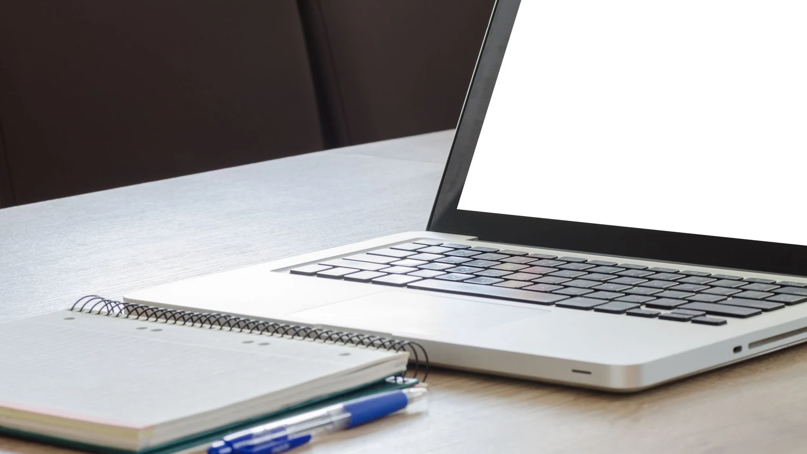 A blank notebook and plain materials on an editorial research desk
